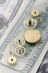 Fototapeta na wymiar Gear wheels on dollar bill revealing the path to success