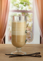 Fragrant coffee latte in glass cup with vanilla pods,