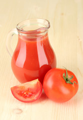 Full jug of tomato juice, on wooden background