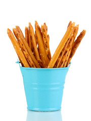 Tasty crispy sticks in blue pail isolated on white