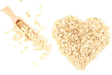 Heart shape made from oat flakes with wooden scoop isolated