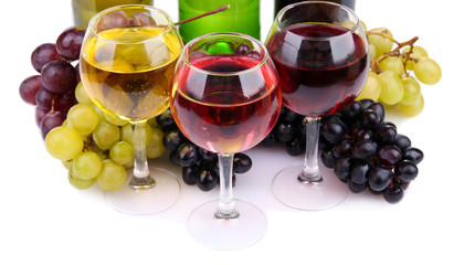 bottles and glasses of wine and assortment of grapes, isolated