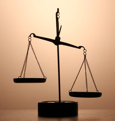 Gold scales of justice on brown background