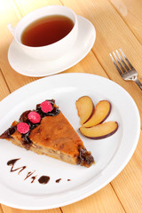 Tasty pie on plate on wooden table