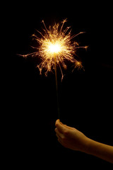 beautiful sparkler in woman hand on black background.