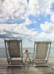 Red cocktail on white table set over ocean