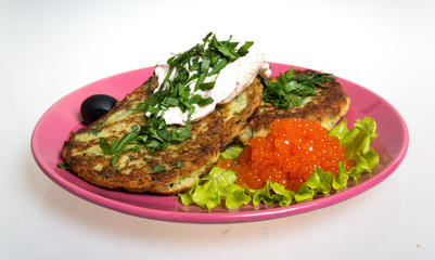 Roasted cutlets of potato with salmon on a plate