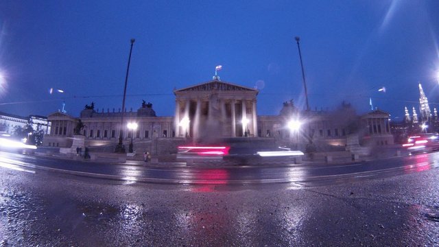 Cars go near to Viennese Parliament when it is raining