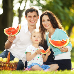 Happy family having a picnic in the green garden