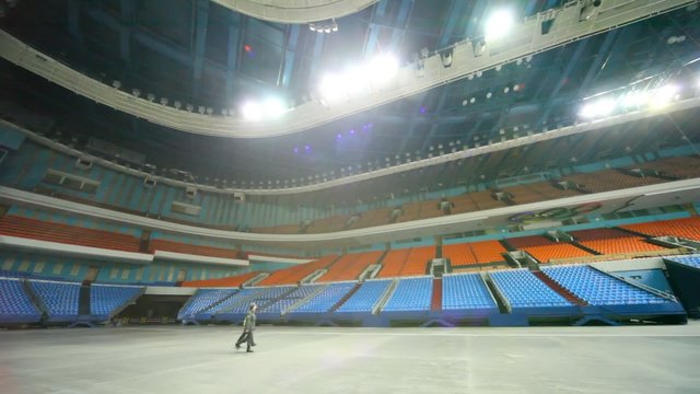 policeman and worker of protection go on huge empty hall