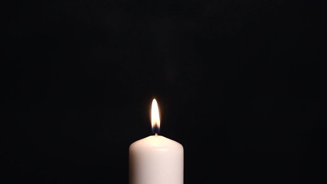 man's hand lights a candle. movement from above