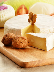 Composition with different sorts of cheese on wooden table