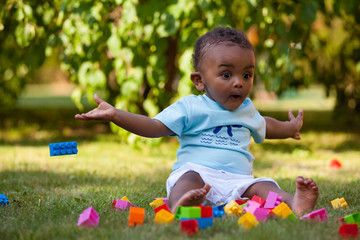 Little african american baby boy playing in the grass