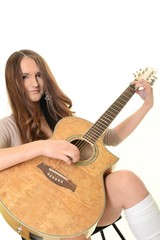 An attractive young teenage woman with an acoustic guitar