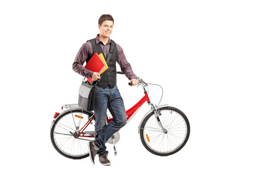 Smiling student holding books next to a bike