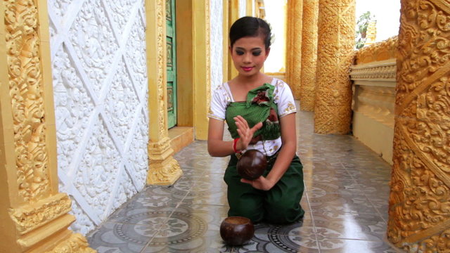 Beautiful Asian Girl performs coconut folk dance in temple