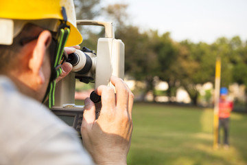 Surveyor engineer with partner making measure on the field