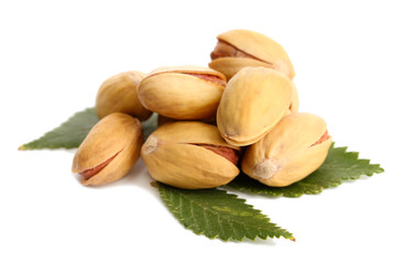 tasty pistachio nuts with leaves, isolated on white