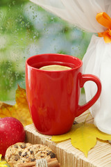 cup of hot tea and autumn leaves, on rain background