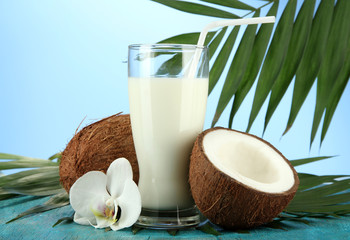 Coconuts with glass of milk,  on blue background