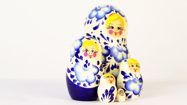 Four russian nesting dolls stand grouped and spin