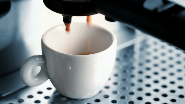 White ceramic cup in a coffee machine, espresso preparing