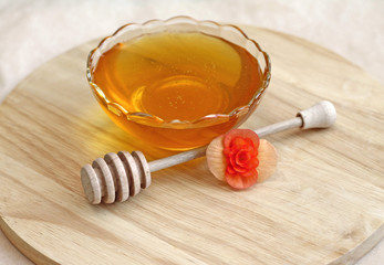 Bowl of honey with wooden drizzler, close-up