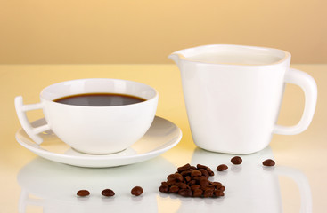 A cup of strong coffee and sweet cream on yellow background