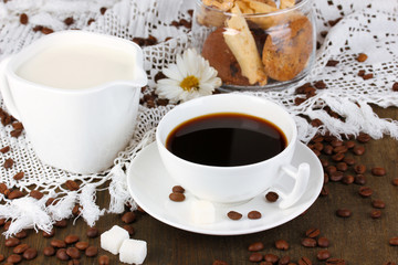 A cup of strong coffee and sweet cream on wooden table close-up