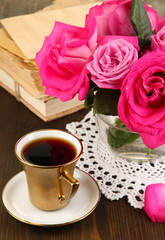 Beautiful pink roses in vase on wooden table close-up