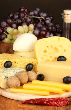 Various types of cheese on wooden board