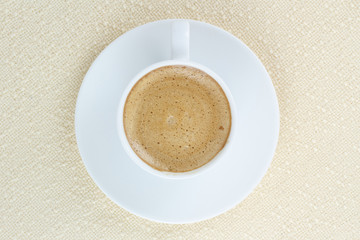 coffee in a white cup on beige tablecloth