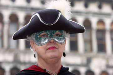 Person in Venetian costume attends Carnival of Venice.