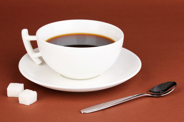 A cup of strong coffee on brown background