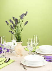 Table setting in violet and green tones on color  background