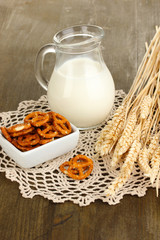 Tasty pretzels in white bowl and milk jug
