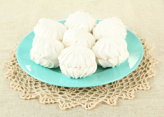 Marshmallows on color plate on light background