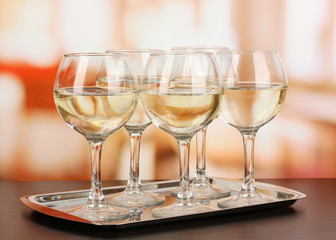 White wine in glass on room background
