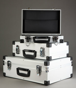 Silvery suitcases on grey background