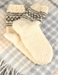 Warm knitted socks on plaid close-up