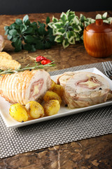 Roulade of stuffed chicken with potatoes and rosemary