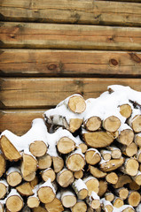 Birch fire wood at a wall of the house in winter