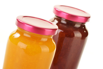 Two jars of fruity jams isolated on white. Preserved fruits