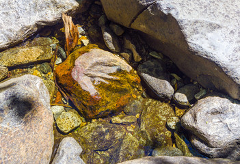 colorful stones in the clear cold water of a creek