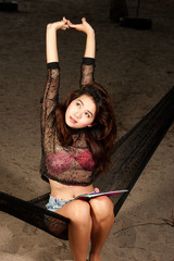 Beautiful Asian woman posing on hammock .