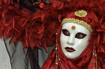 Person in Venetian costume attends Carnival of Venice.