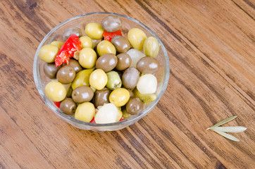 Olives and pickles on wood table