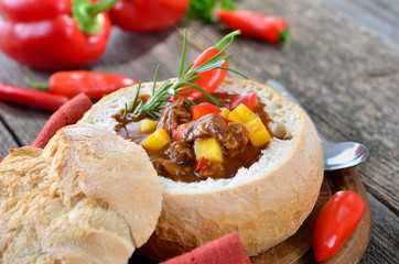 Feurige Gulaschsuppe im Brotlaib serviert