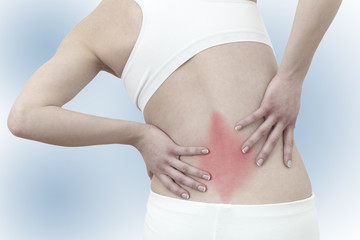 Acute pain in a woman back. Female from behind holding hand to s