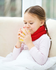 Ill little girl is drinking vitamin cocktail